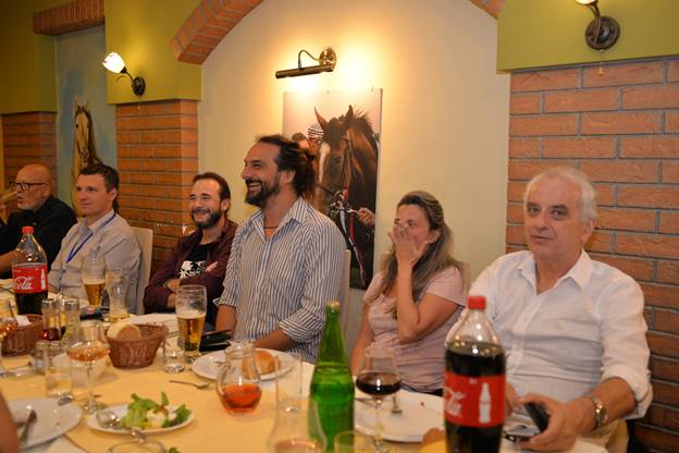 A group of people sitting at a table with wine glasses

Description generated with very high confidence