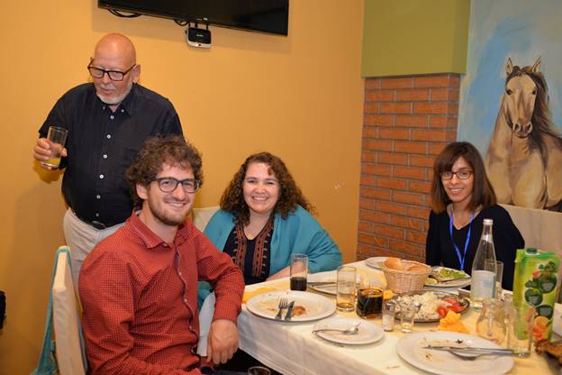 A group of people sitting at a dinner table

Description generated with very high confidence