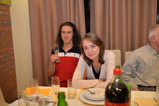 A group of people sitting at a table with wine glasses

Description generated with very high confidence