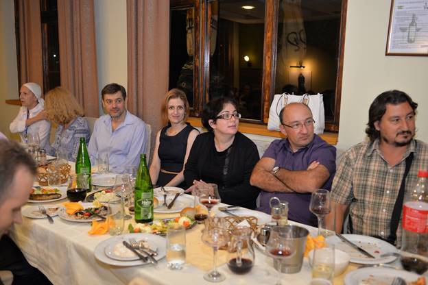 A group of people sitting at a dinner table

Description generated with very high confidence