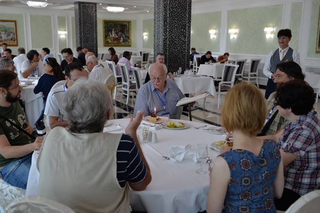 A group of people sitting at a table

Description generated with very high confidence