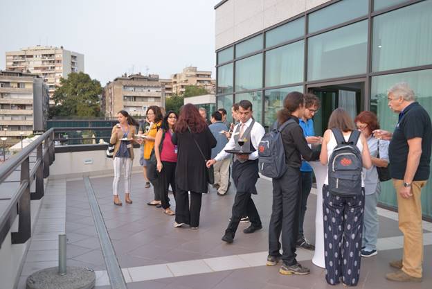 A group of people standing in front of a building

Description generated with very high confidence