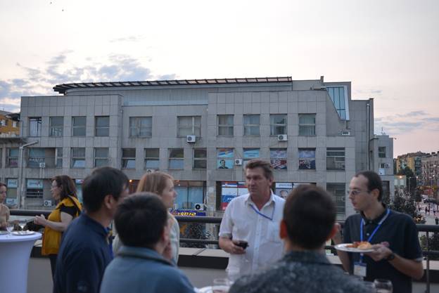 A group of people standing in front of a building

Description generated with very high confidence