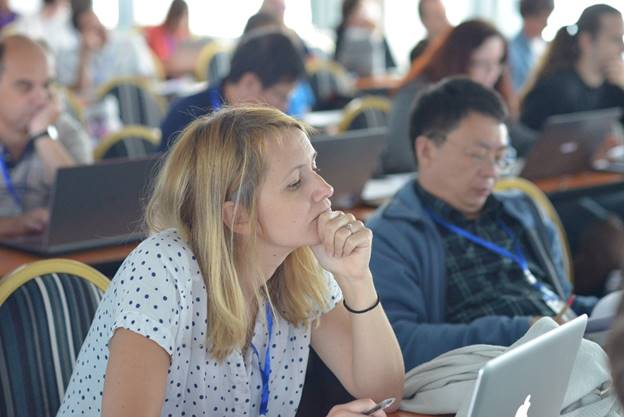 A group of people sitting at a table using a computer

Description generated with very high confidence