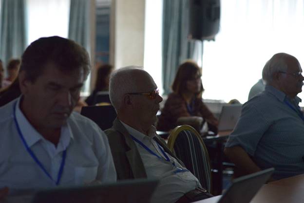 A group of people sitting at a table using a computer

Description generated with very high confidence