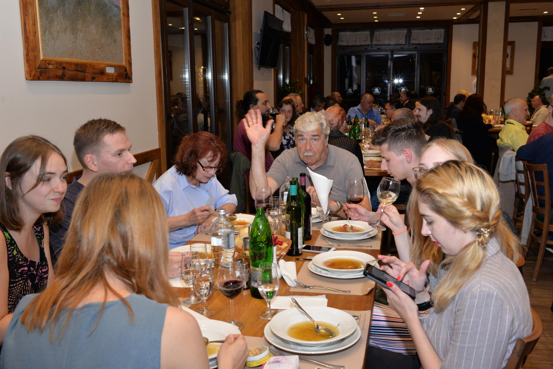 A group of people sitting at a table in a restaurant

Description automatically generated