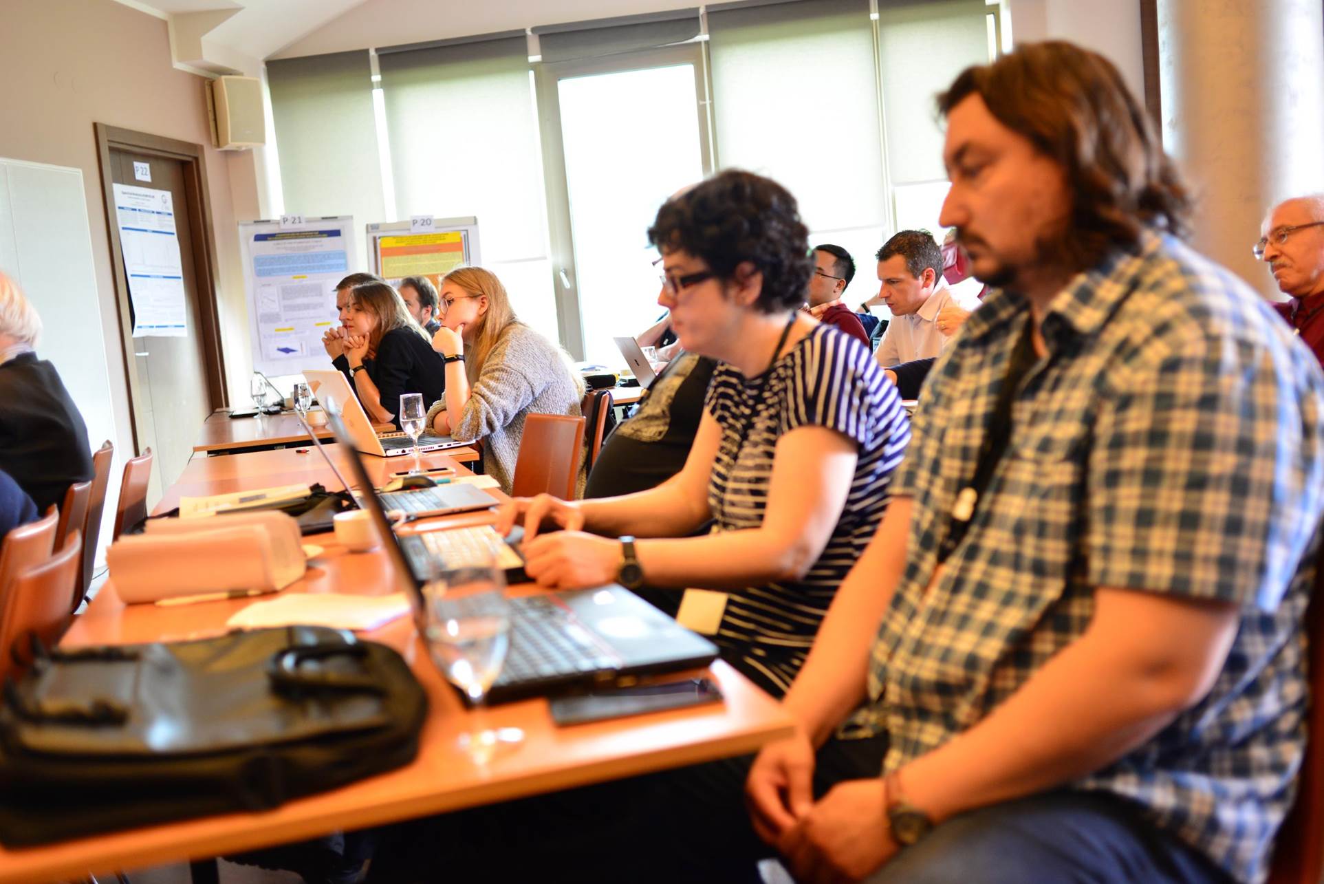 A group of people sitting at a table using a computer

Description automatically generated