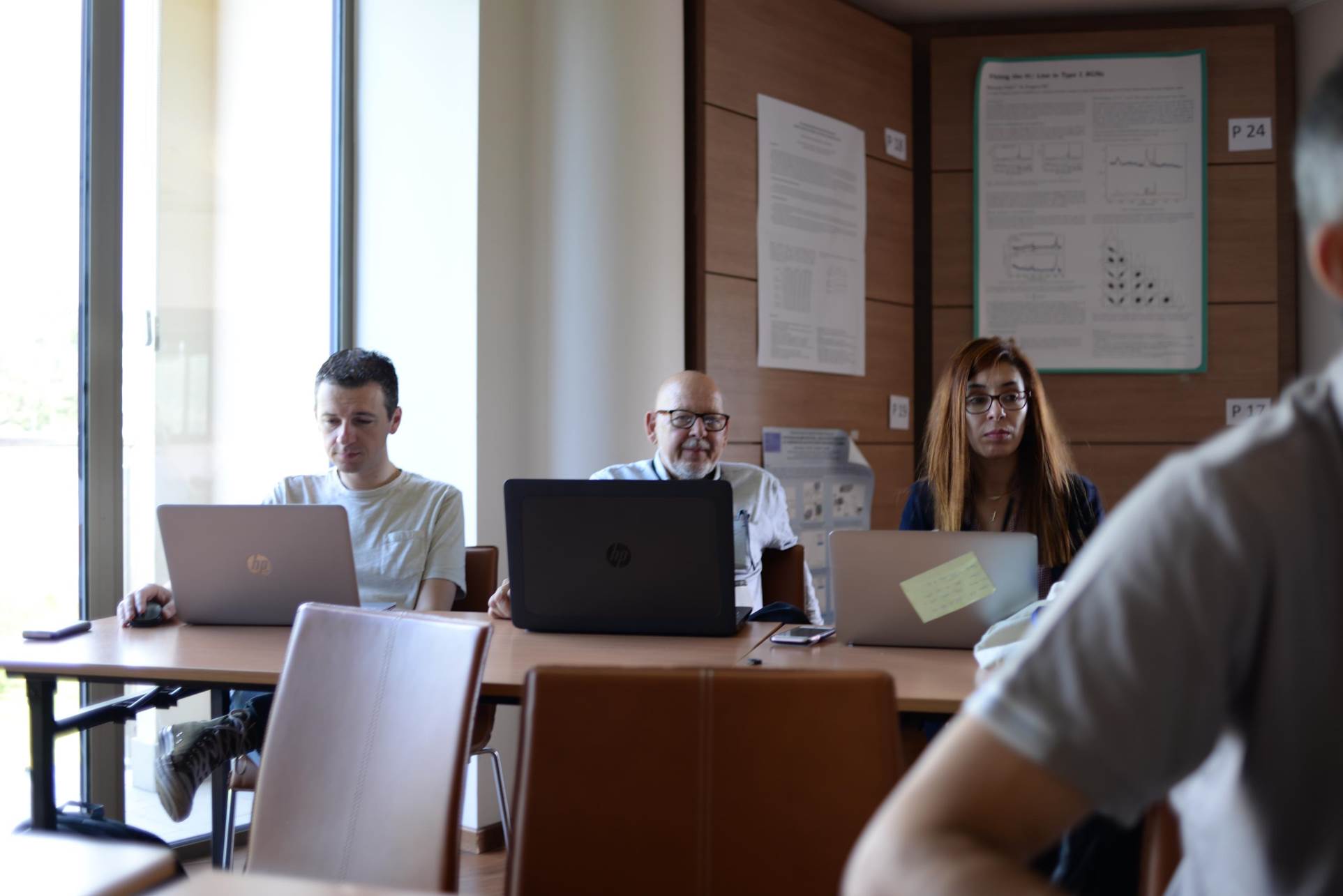 A person sitting at a table with a computer

Description automatically generated