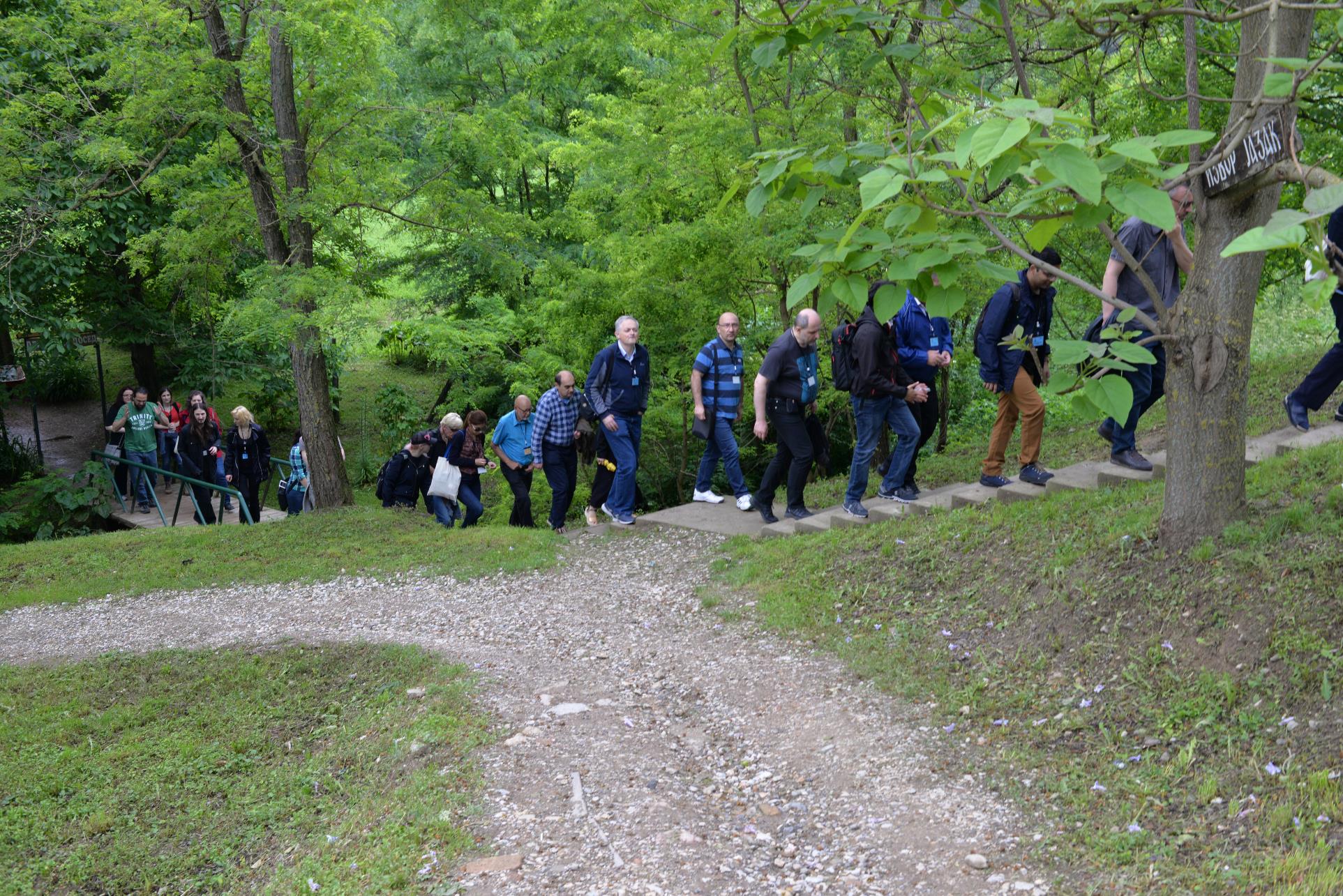 A group of people walking down a dirt road

Description automatically generated