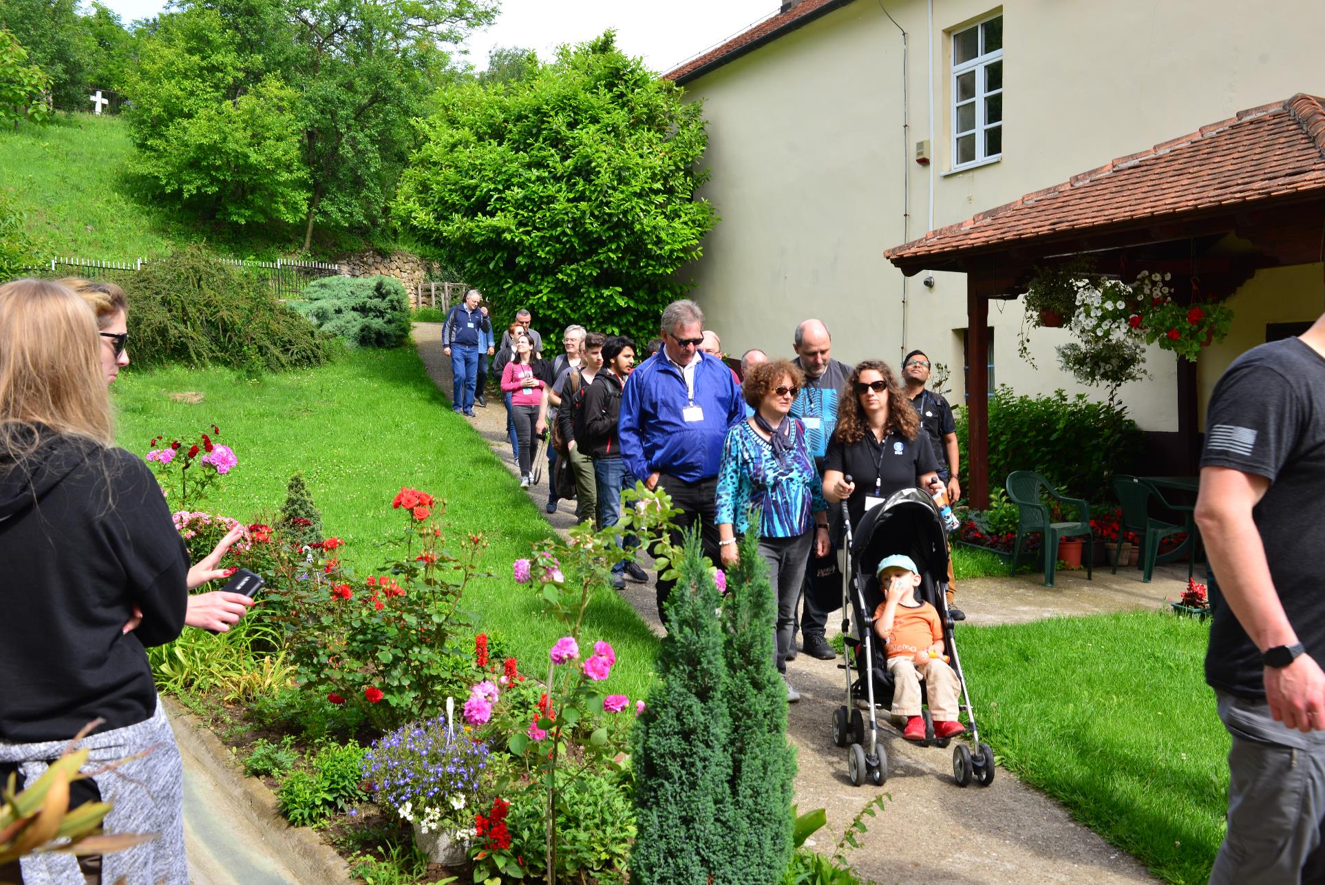 A group of people standing in a garden

Description automatically generated