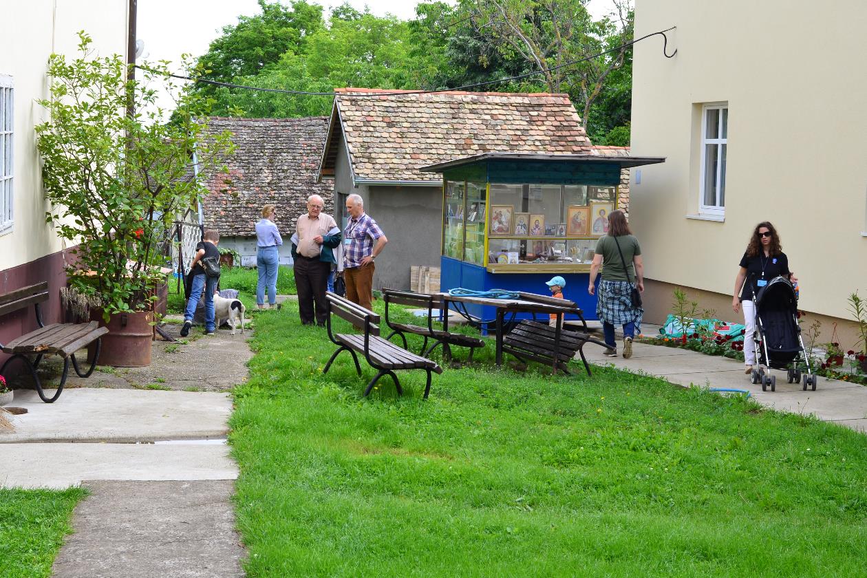 A group of people sitting in front of a house

Description automatically generated