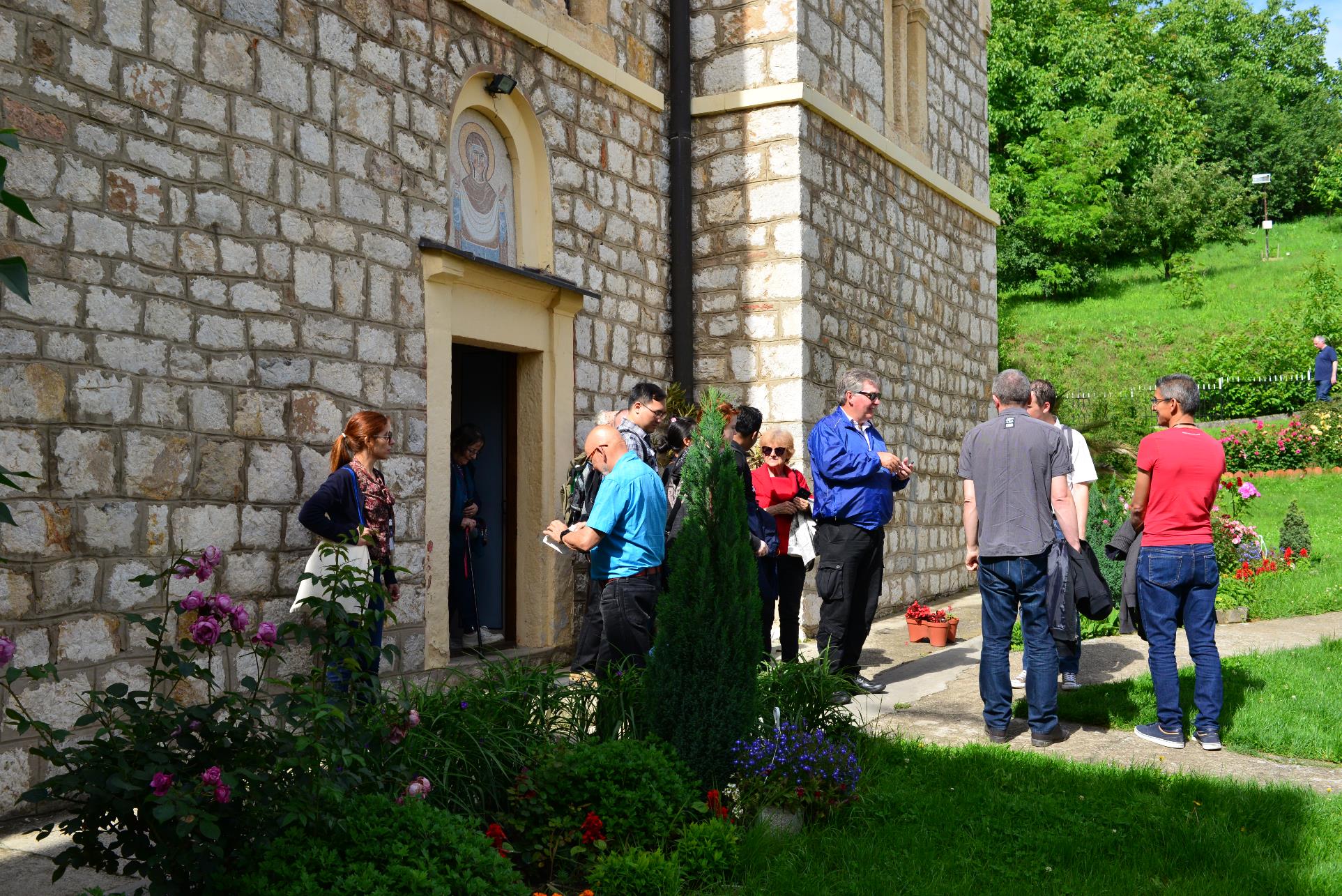 A group of people standing in front of a building

Description automatically generated