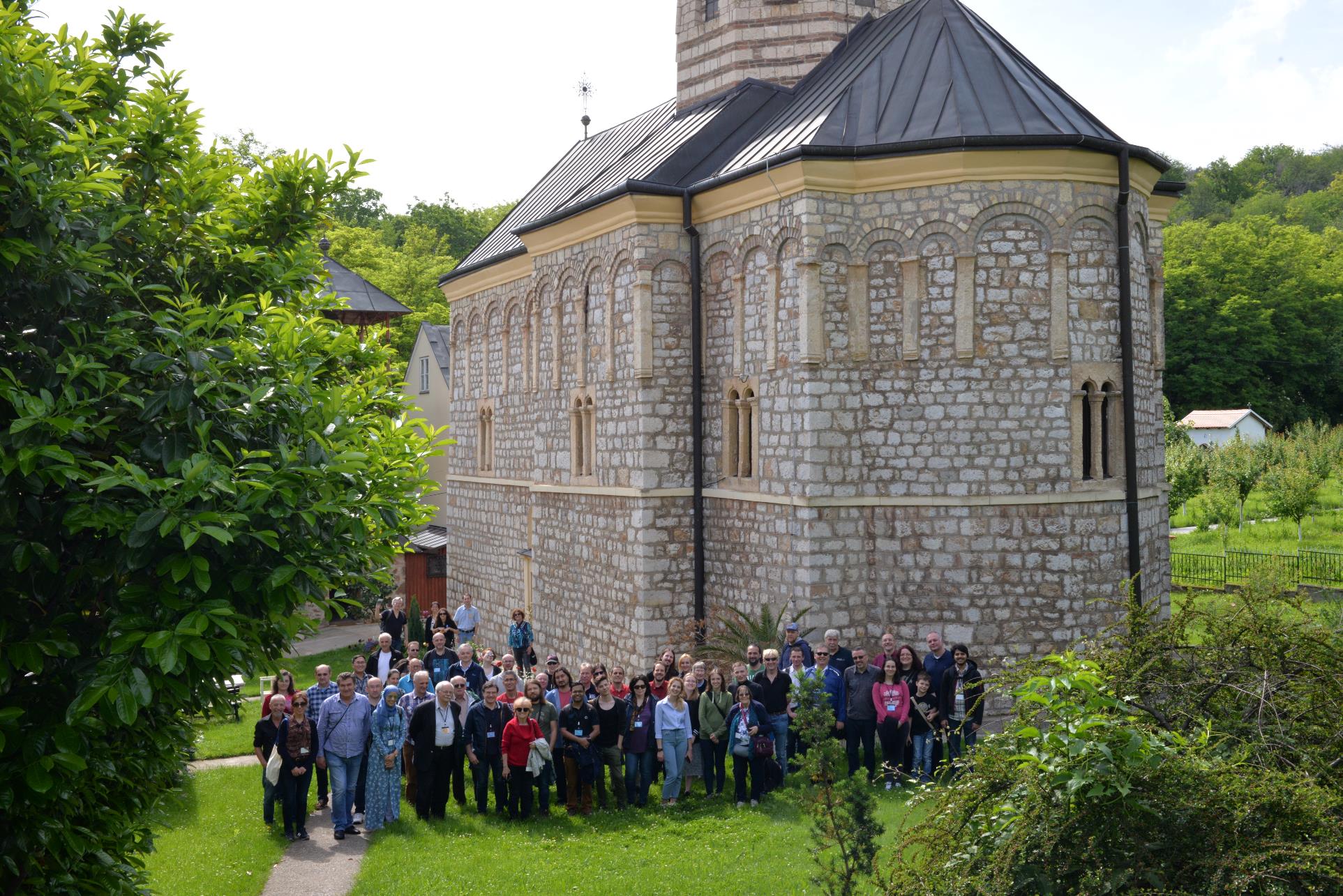 A group of people standing in front of a house

Description automatically generated