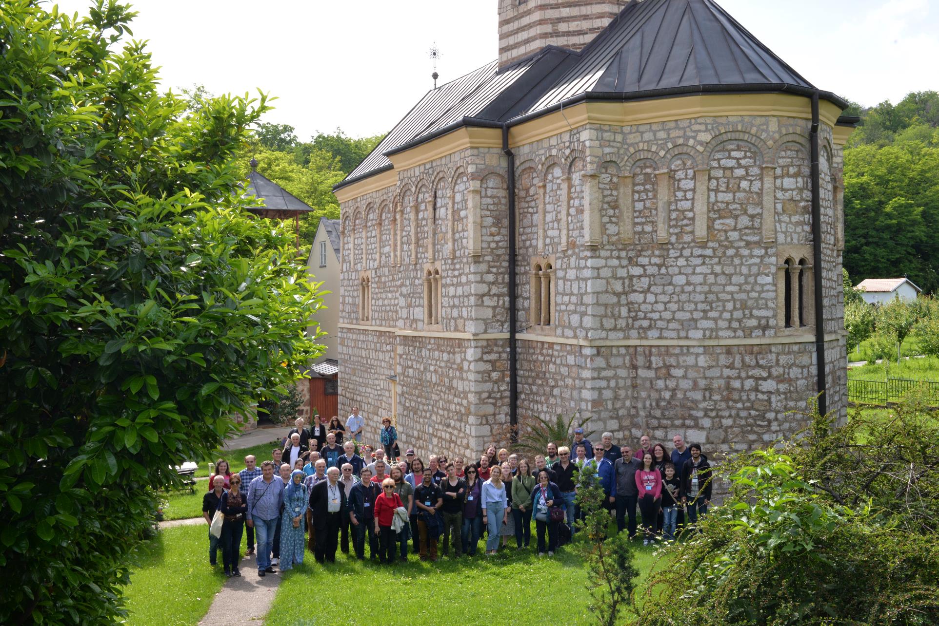 A group of people standing in front of a building

Description automatically generated