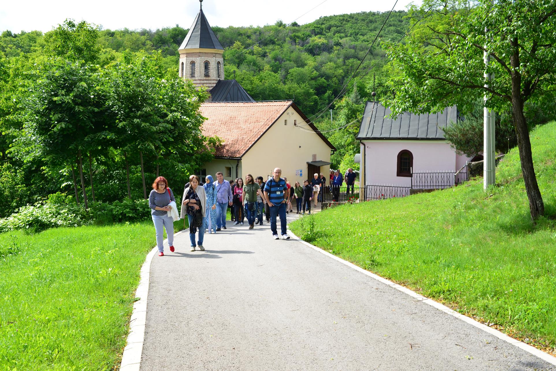 A group of people on a sidewalk in front of a house

Description automatically generated