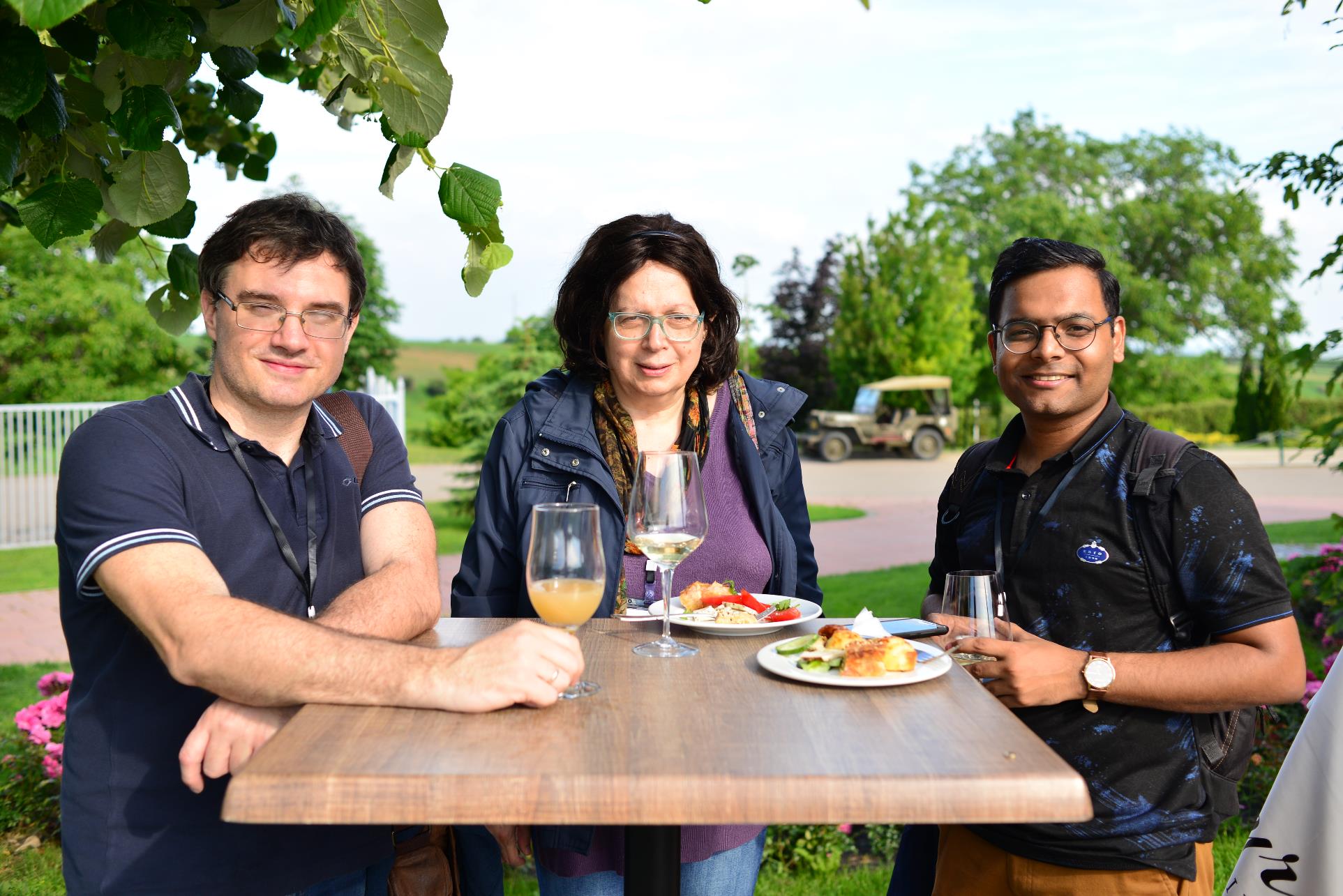 A group of people sitting at a picnic table posing for the camera

Description automatically generated