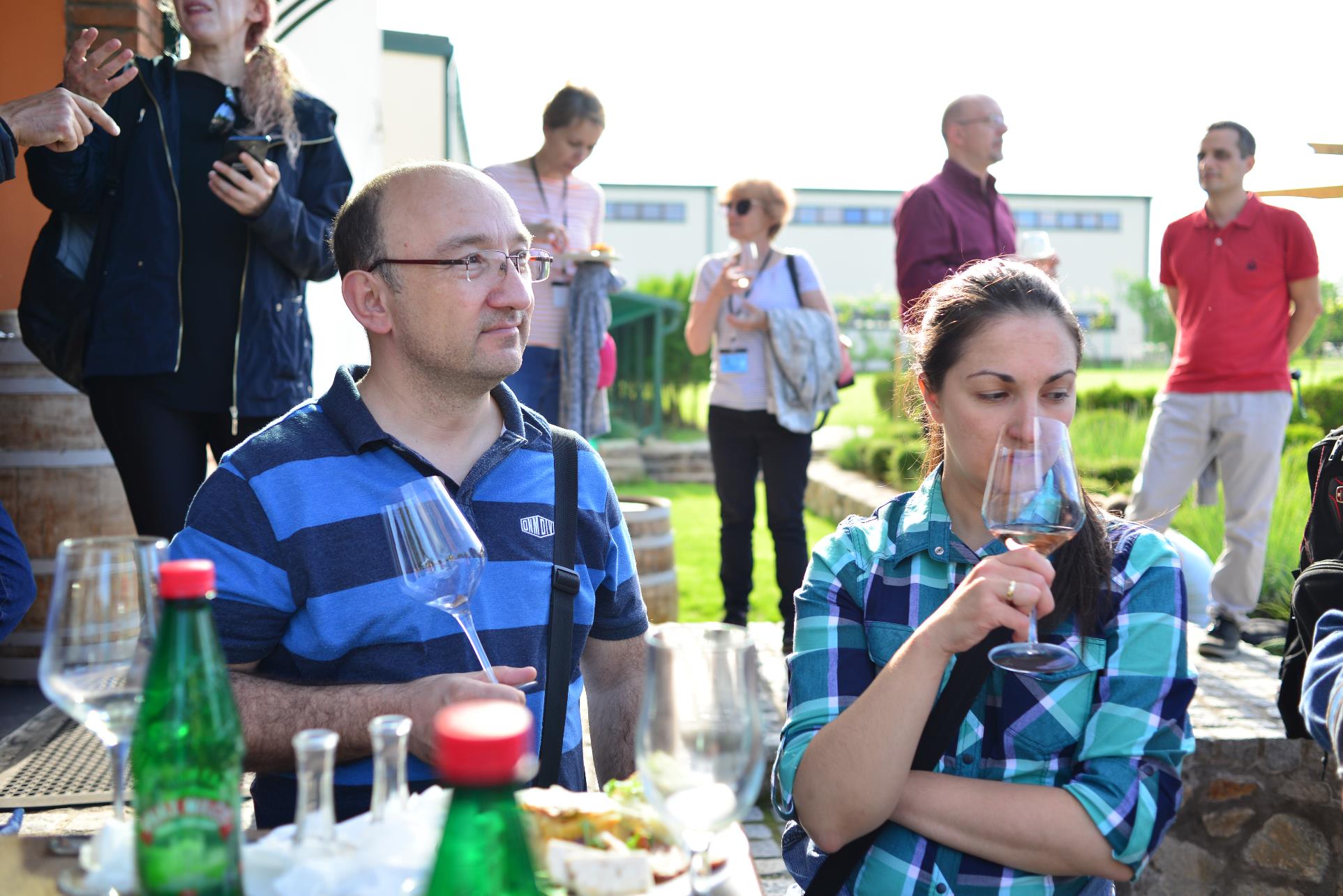 A group of people are drinking from a wine bottle

Description automatically generated