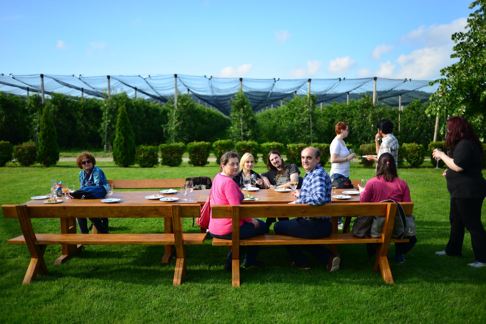 A group of people sitting at a picnic table

Description automatically generated